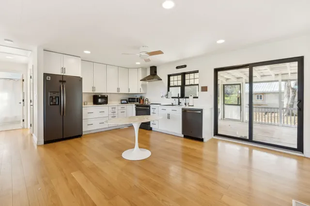 a kitchen with white cabinets and clock on the wall