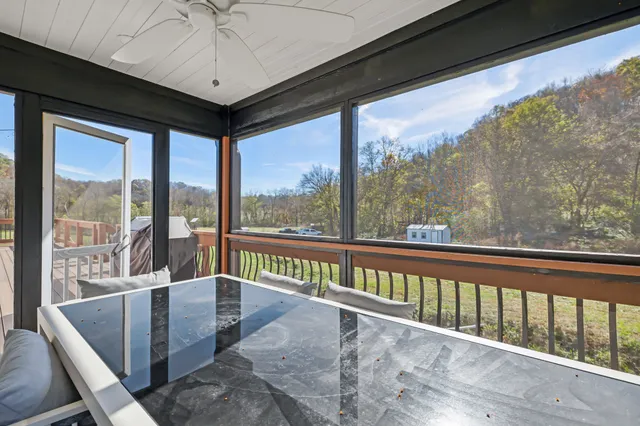 a kitchen with stainless steel appliances a sink dishwasher a stove top oven a refrigerator with white cabinets and wooden floor