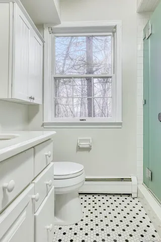 a bathroom with a sink a toilet and a window