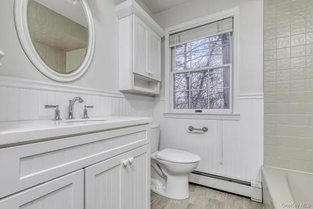 a bathroom with a toilet a sink and mirror