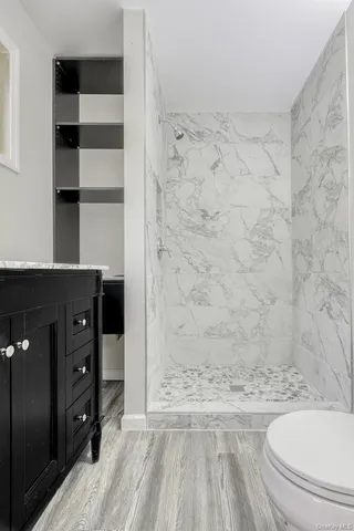 a bathroom with a granite countertop sink toilet and shower