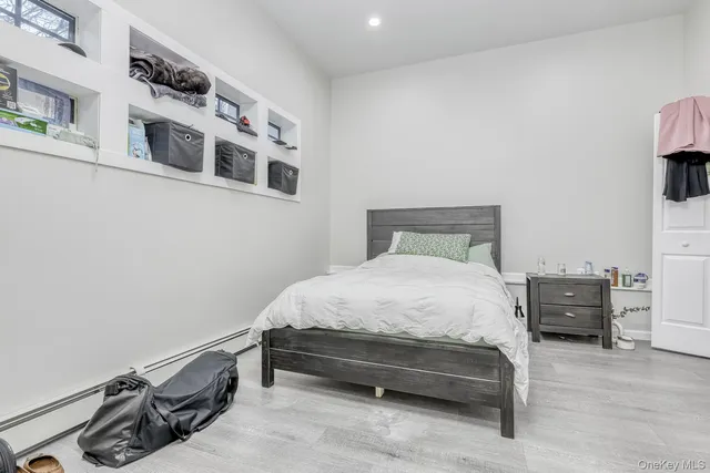 a bedroom with a bed and a flat tv screen on the dresser