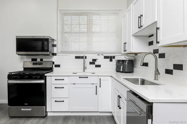 a kitchen with cabinets appliances a sink and a window