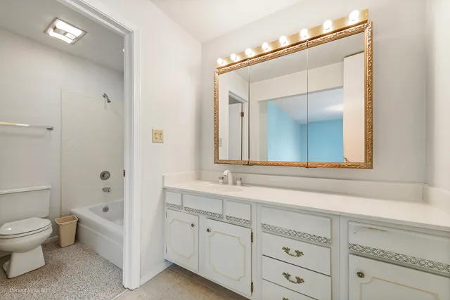 a spacious bathroom with a toilet sink and mirror