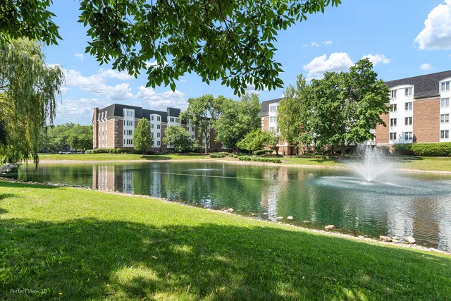 a view of a house next to a lake with a big yard