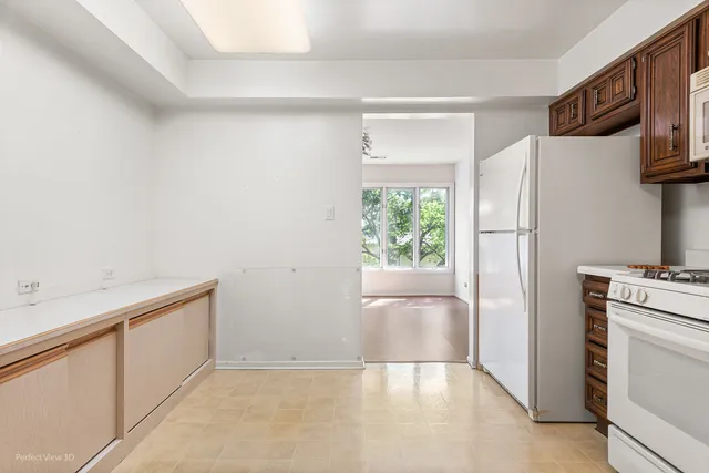 a view of kitchen with furniture and refrigerator