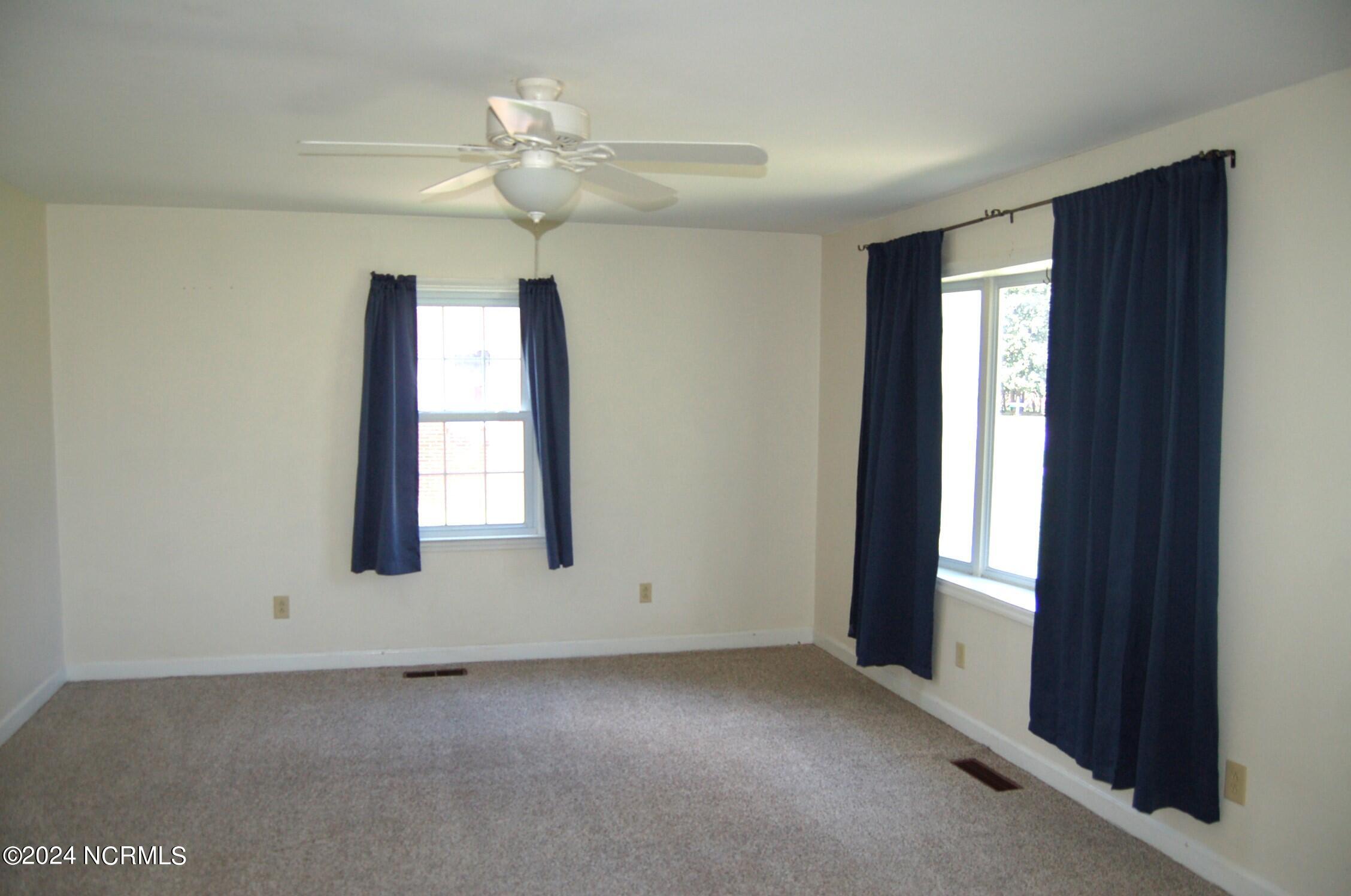 617 Lee Drive Havelock, NC 28532 - Photo 6 of 20 Light and airy space with new carpet and paint. The room features a ceiling fan and a built in bookcase.