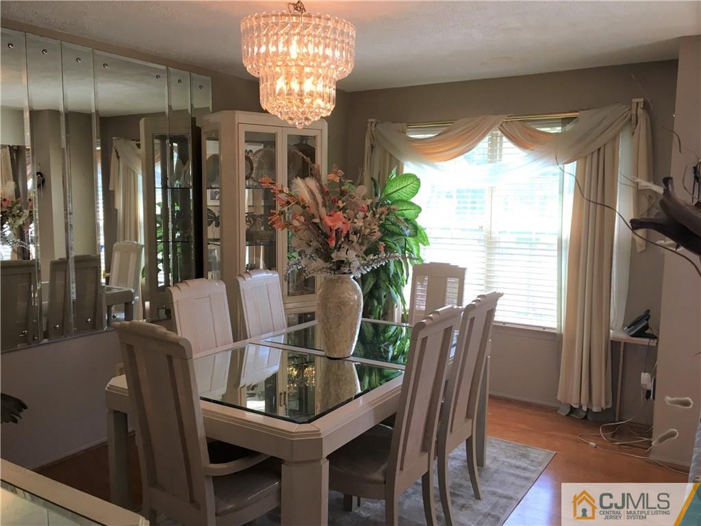 171 Salem Road North Brunswick, NJ 08902 - Photo 7 of 44 a view of a dining room with furniture a chandelier and wooden floor