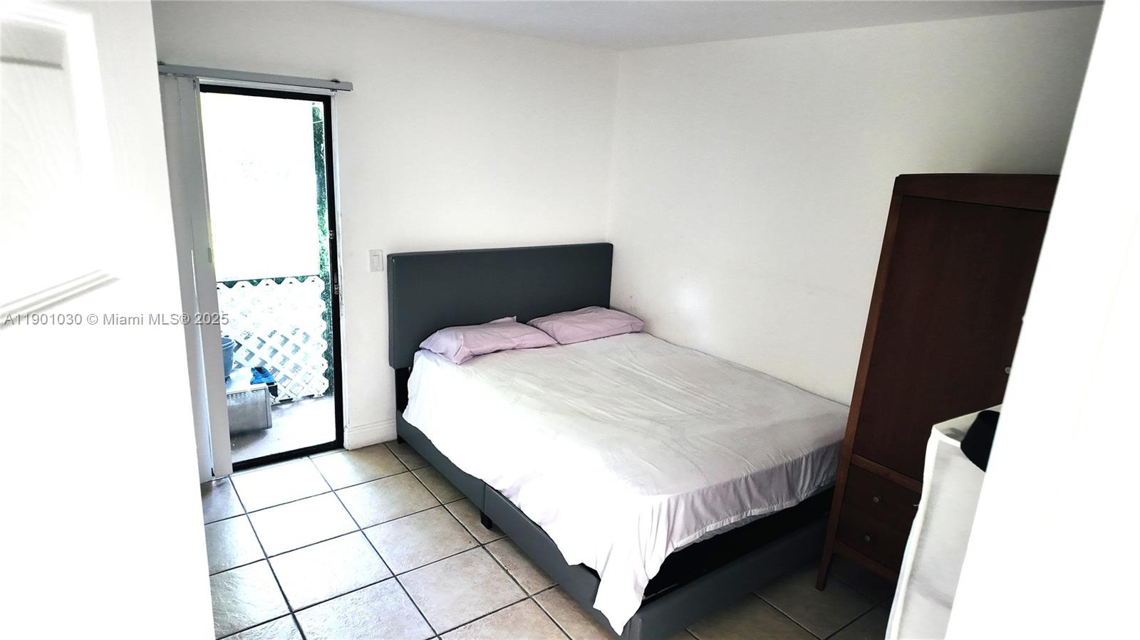 3037 Northwest 118th Drive, Unit 122D Coral Springs, FL 33065 - Photo 12 of 25 a bedroom with a bed and a window