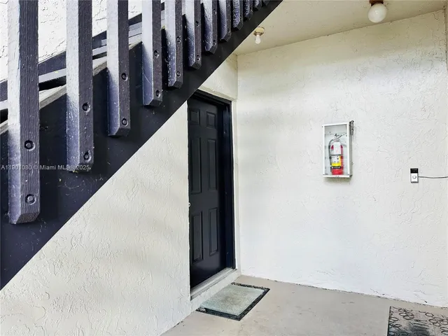a view of staircase with lots of frames on wall and wooden floor