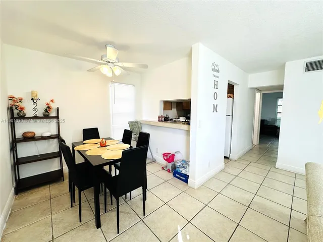 a view of a dining room with furniture and a chandelier fan
