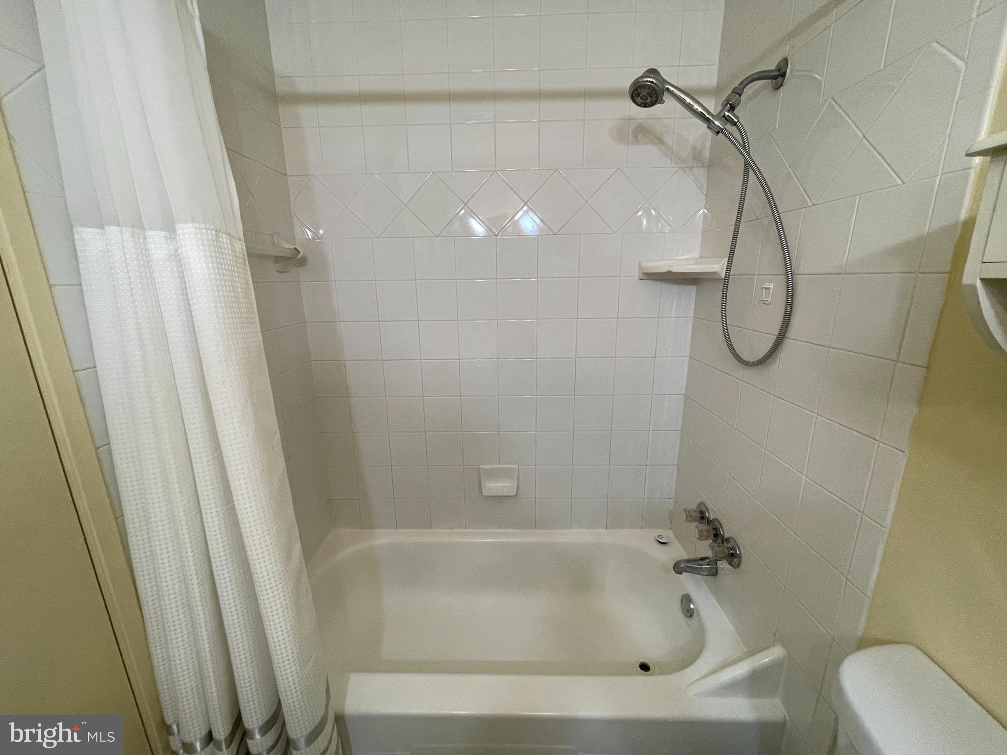 9653 White Acre Road, Unit C2 Columbia, MD 21045 - Photo 7 of 11 a bathroom with a bath tub with a shower