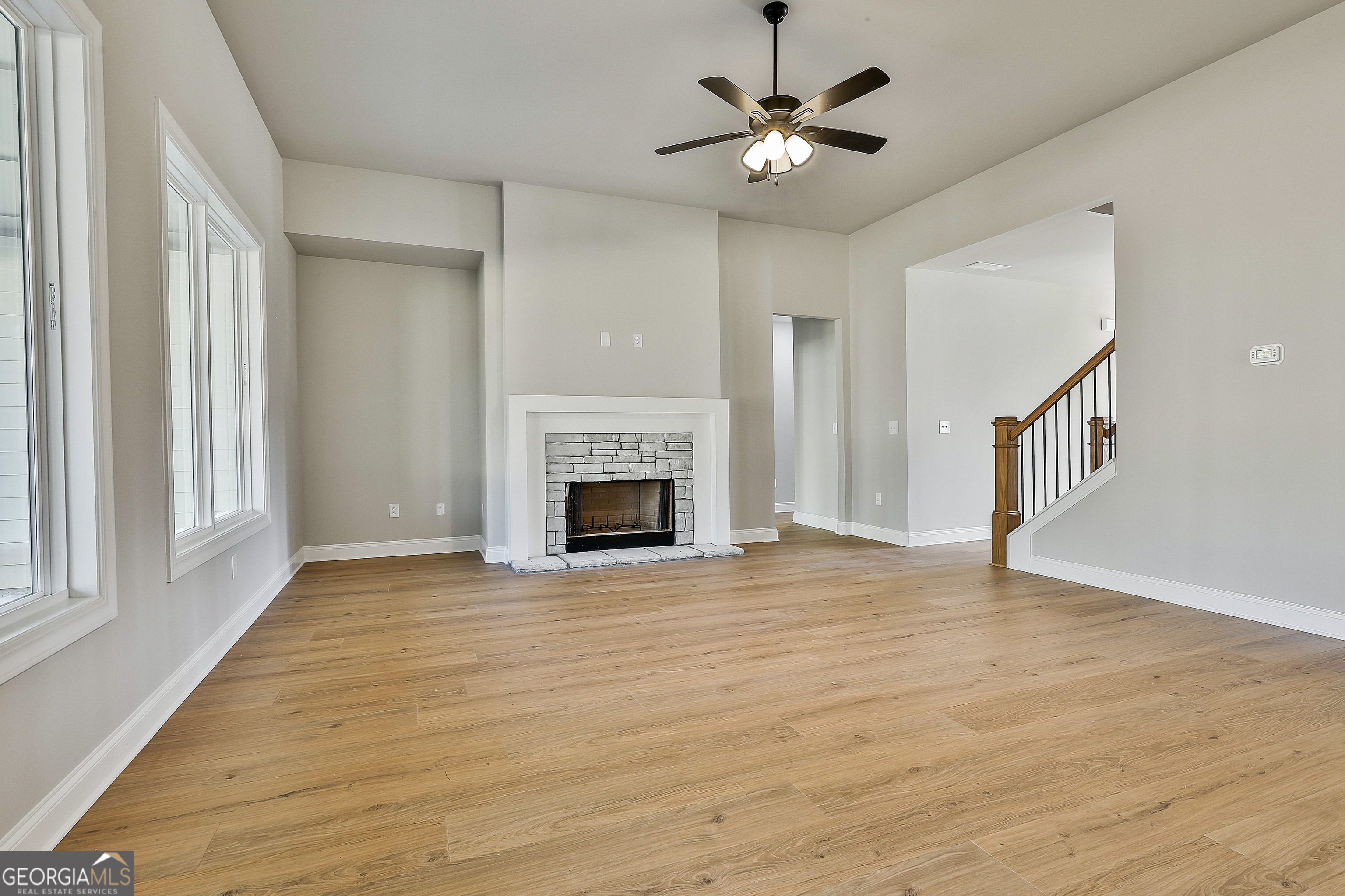 174 Tattersall Way, Unit 5100 Senoia, GA 30276 - Photo 11 of 40 a view of an empty room with chandelier fan and wooden floor