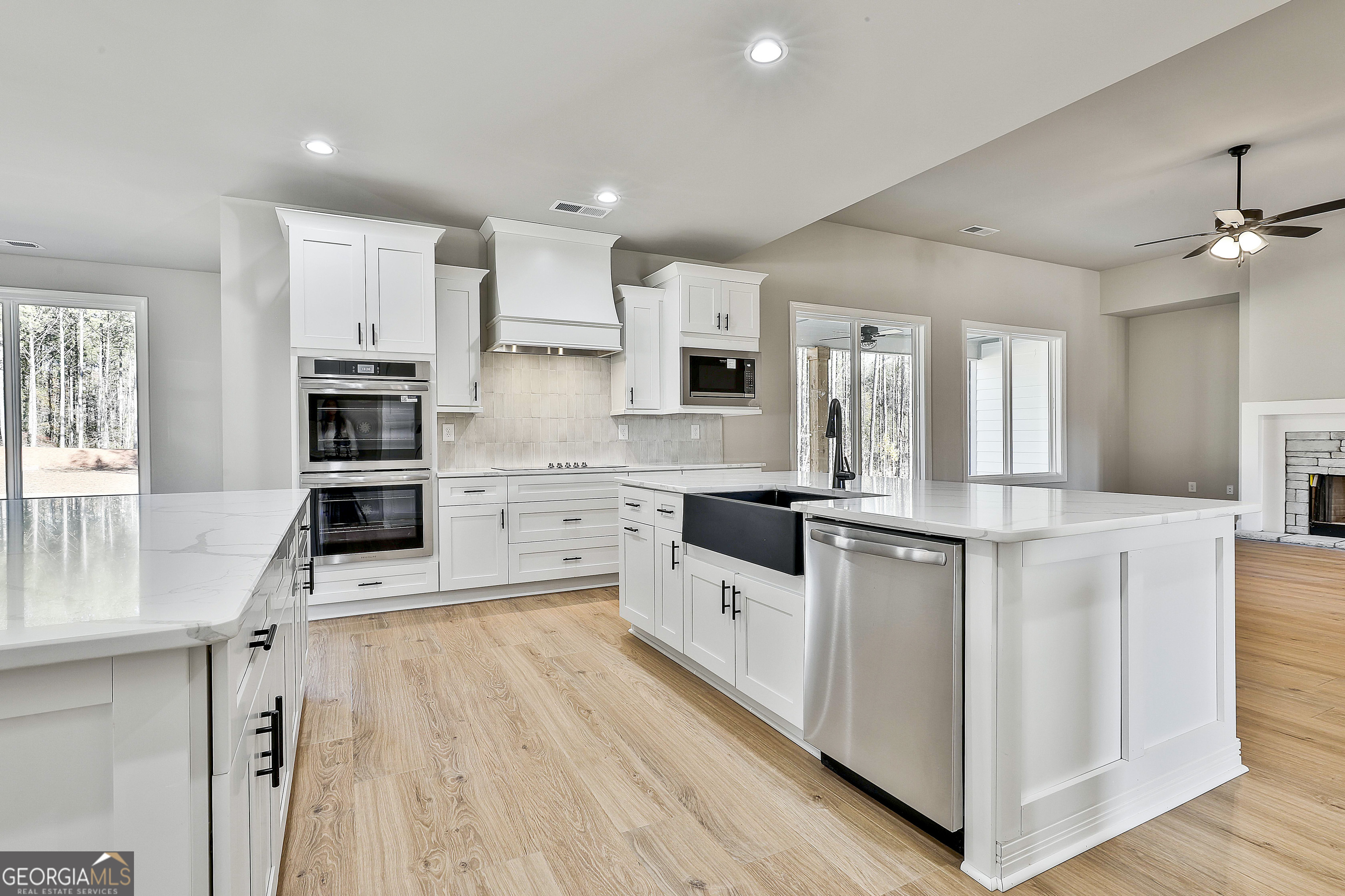 174 Tattersall Way, Unit 5100 Senoia, GA 30276 - Photo 20 of 40 a kitchen with stainless steel appliances kitchen island granite countertop a stove a sink and a refrigerator