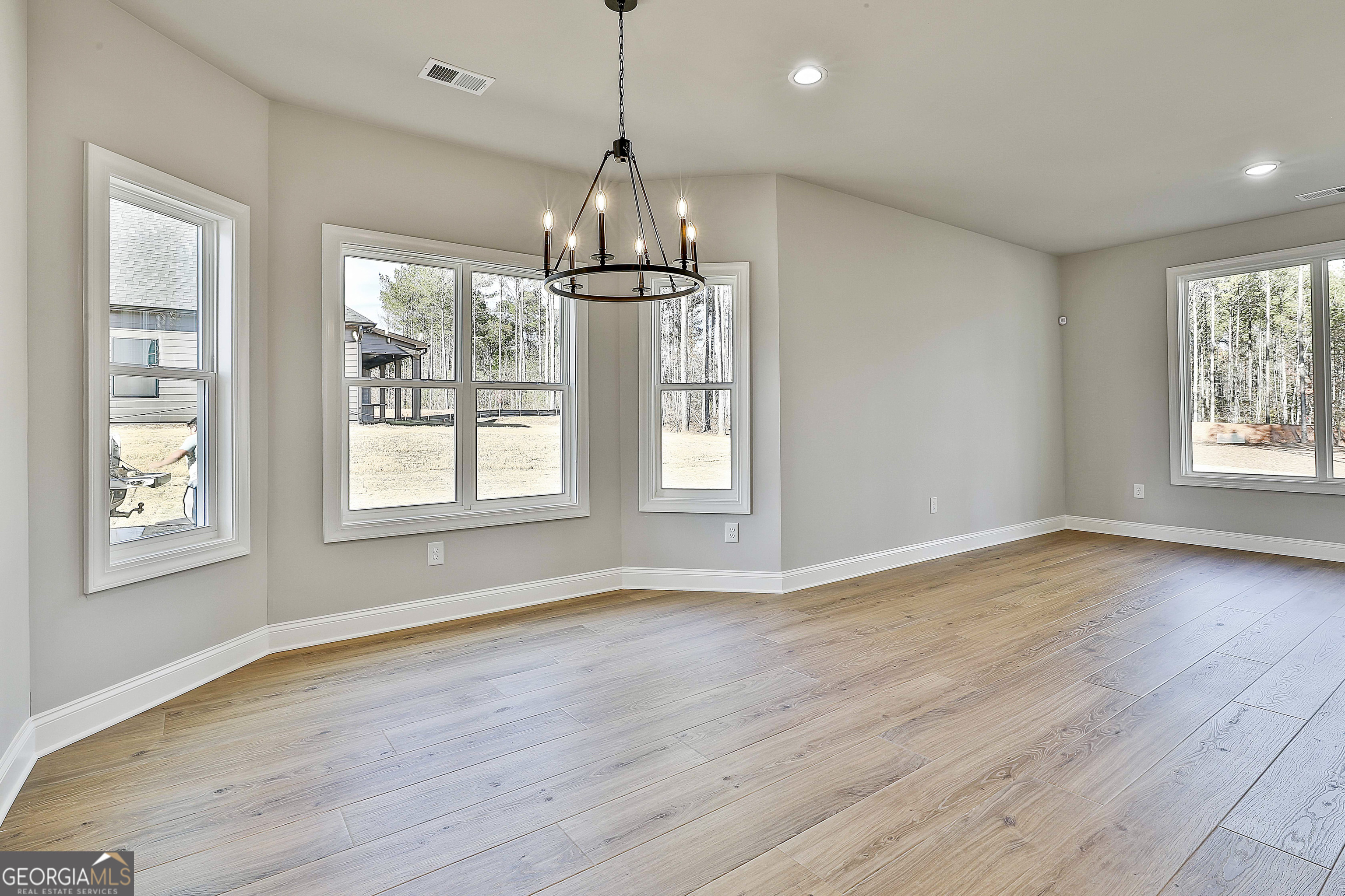 174 Tattersall Way, Unit 5100 Senoia, GA 30276 - Photo 21 of 40 a view of an empty room with wooden floor and a window