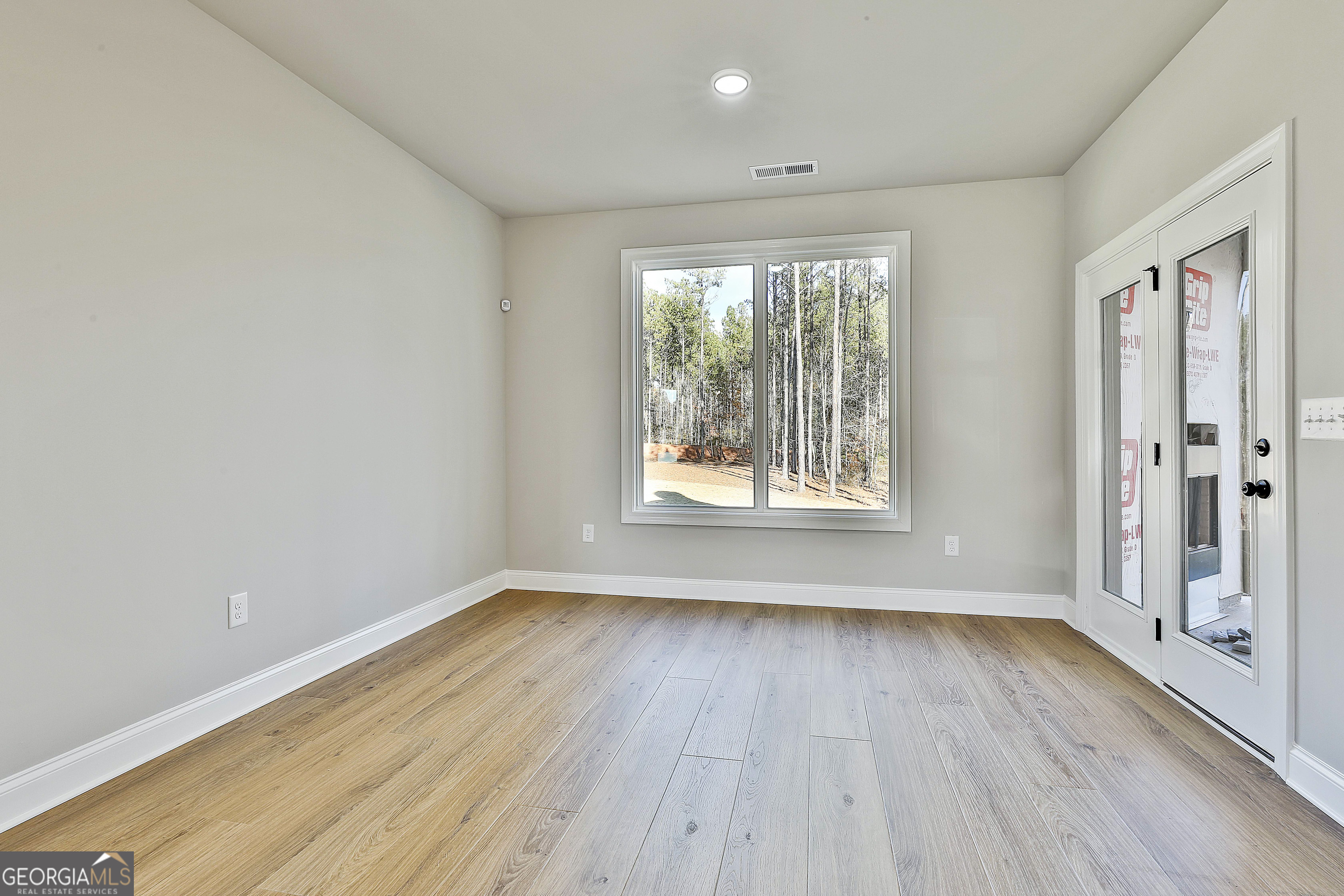 174 Tattersall Way, Unit 5100 Senoia, GA 30276 - Photo 24 of 40 an empty room with wooden floor and windows
