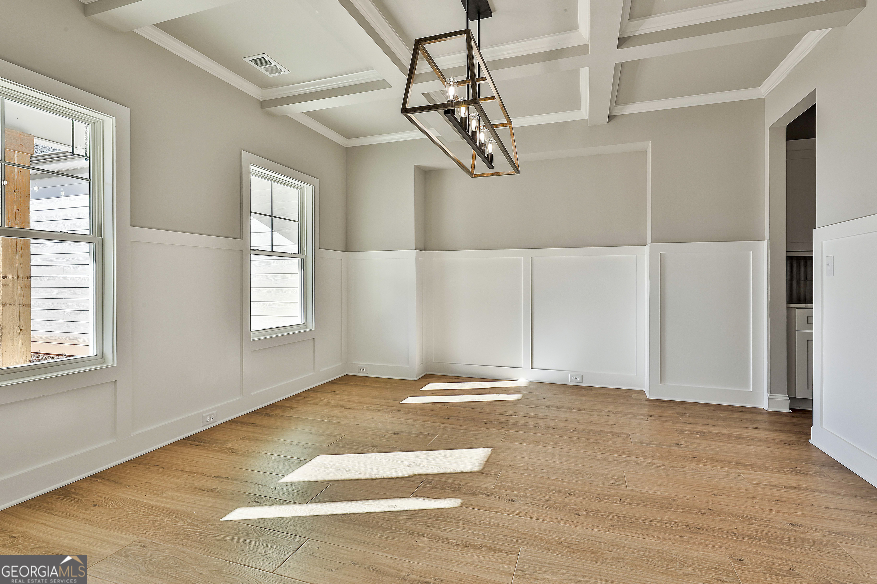174 Tattersall Way, Unit 5100 Senoia, GA 30276 - Photo 5 of 40 a view of an empty room with wooden floor and a window
