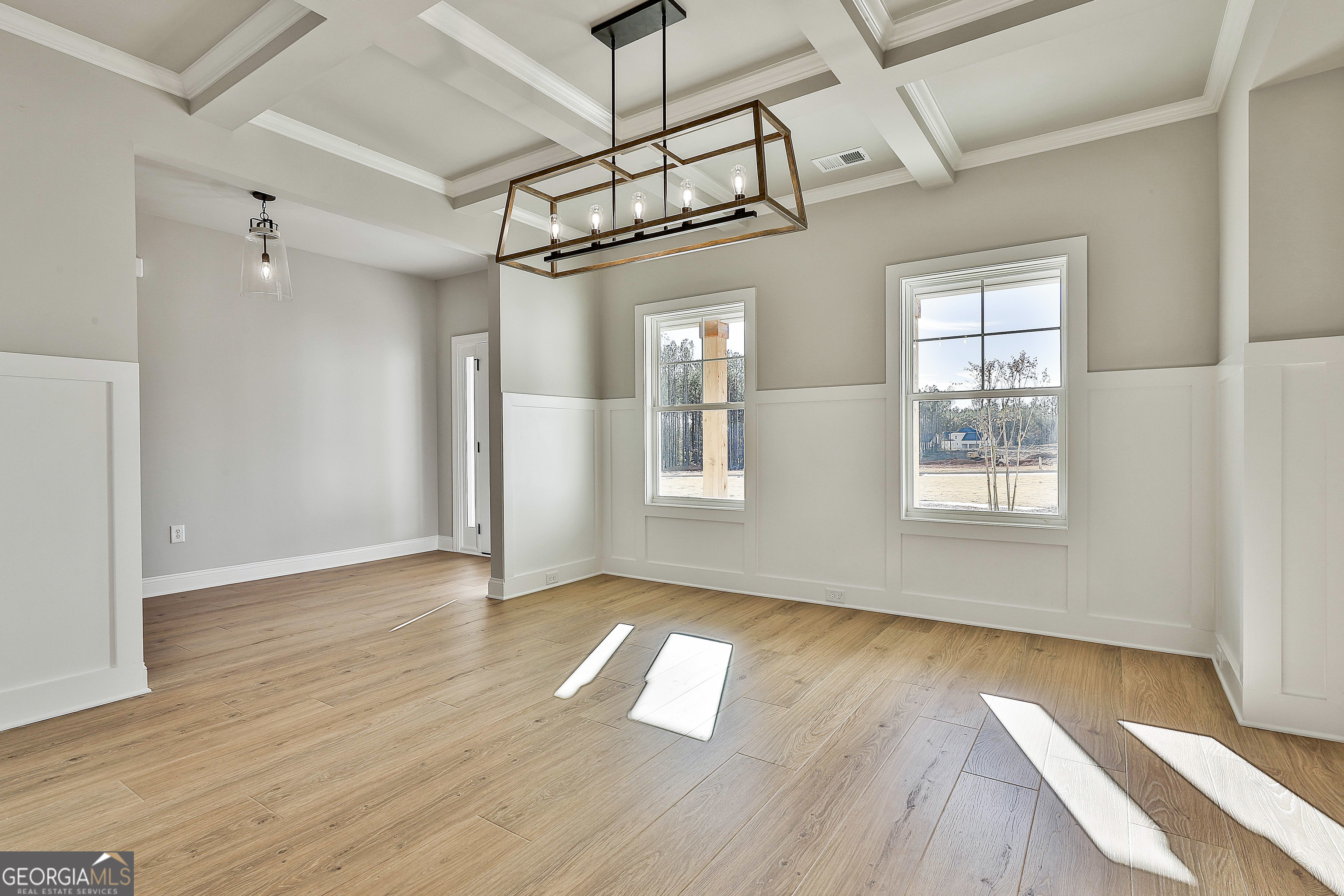 174 Tattersall Way, Unit 5100 Senoia, GA 30276 - Photo 6 of 40 a view of an empty room with wooden floor and a window