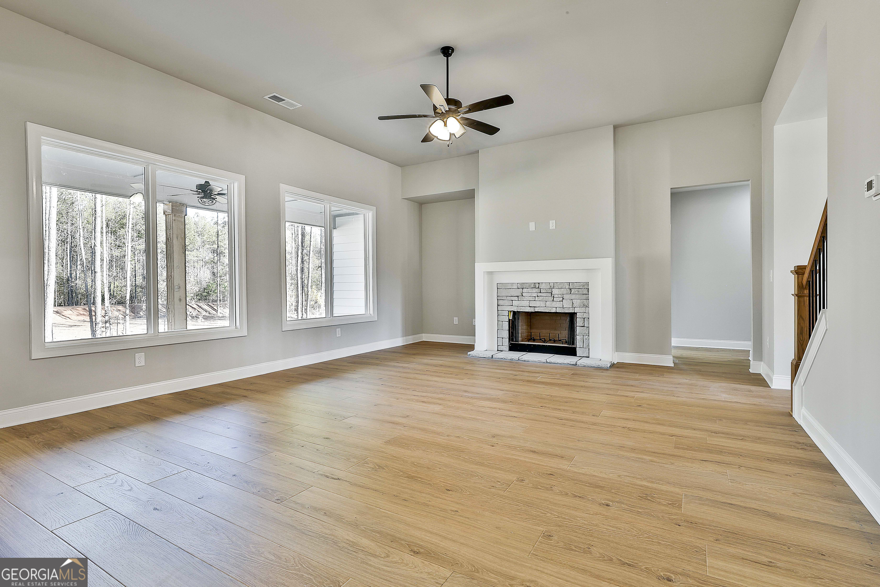 174 Tattersall Way, Unit 5100 Senoia, GA 30276 - Photo 10 of 40 a view of an empty room with wooden floor fireplace and a window