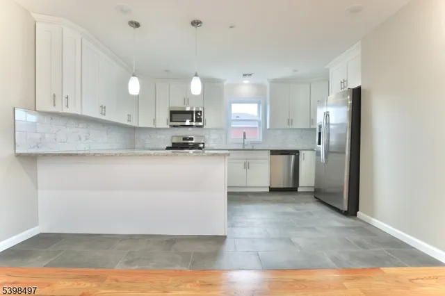 a kitchen with stainless steel appliances granite countertop a refrigerator sink and cabinets