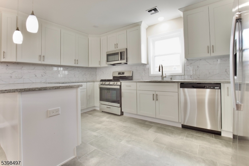 32 Garibaldi Avenue, Unit 3 Newark, NJ 07114 - Photo 3 of 20 a kitchen with white cabinets stainless steel appliances and sink