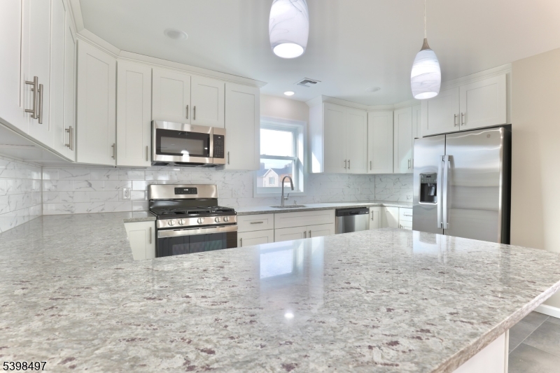 32 Garibaldi Avenue, Unit 3 Newark, NJ 07114 - Photo 4 of 20 a kitchen with kitchen island a counter space a sink appliances and cabinets