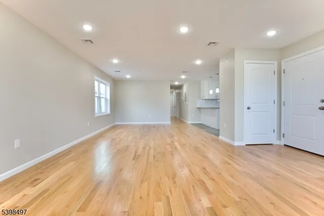 a view of empty room with wooden floor and window