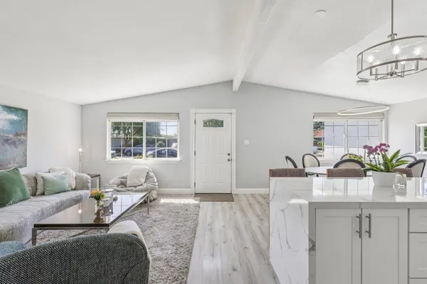 a living room with lots of furniture and kitchen view