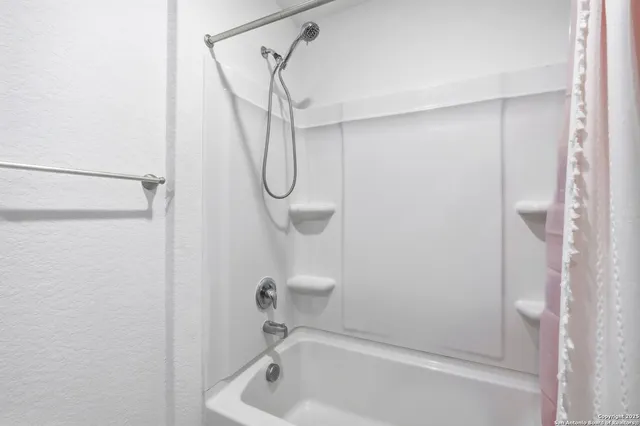 a bathroom with a bath tub with a shower