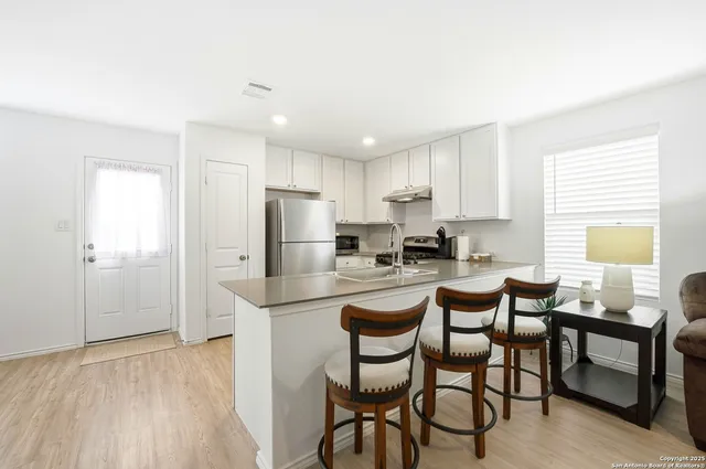 a kitchen with refrigerator and chairs