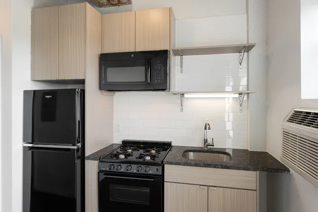 a kitchen with appliances a sink and cabinets