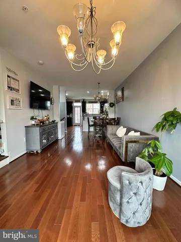 a living room with furniture chandelier and a flat screen tv