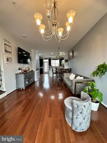 a view of a dining room with furniture a chandelier and wooden floor