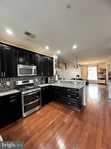 a kitchen with stainless steel appliances kitchen island granite countertop a stove top oven a sink and dishwasher
