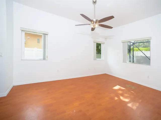 an empty room with a window and a fan