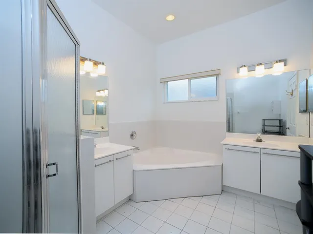 a bathroom with a tub a sink and mirror