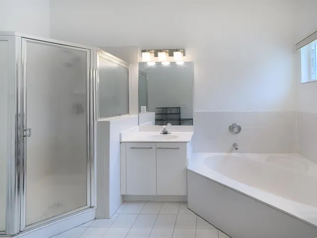 a bathroom with a bathtub sink vanity and mirror