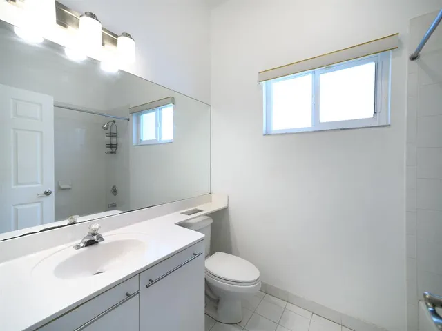a bathroom with a sink a toilet and mirror
