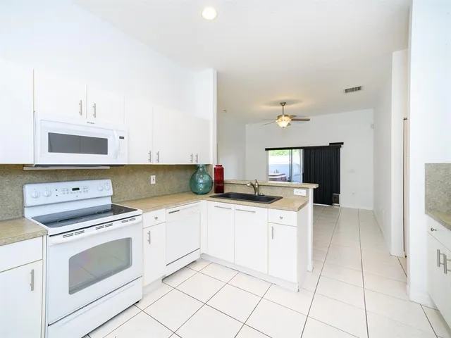 a kitchen with a stove sink and cabinets
