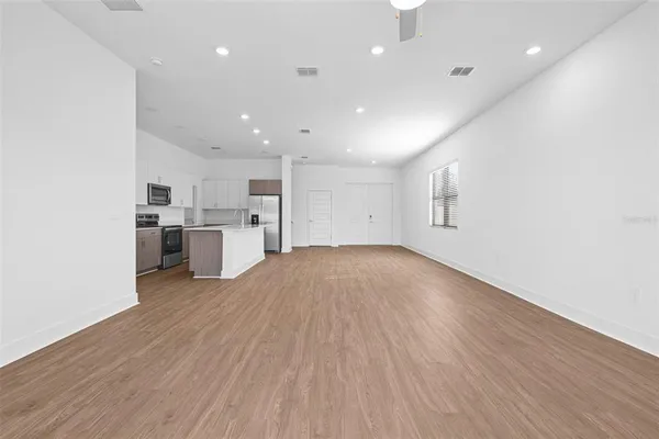 a view of kitchen with wooden floor and electronic appliances