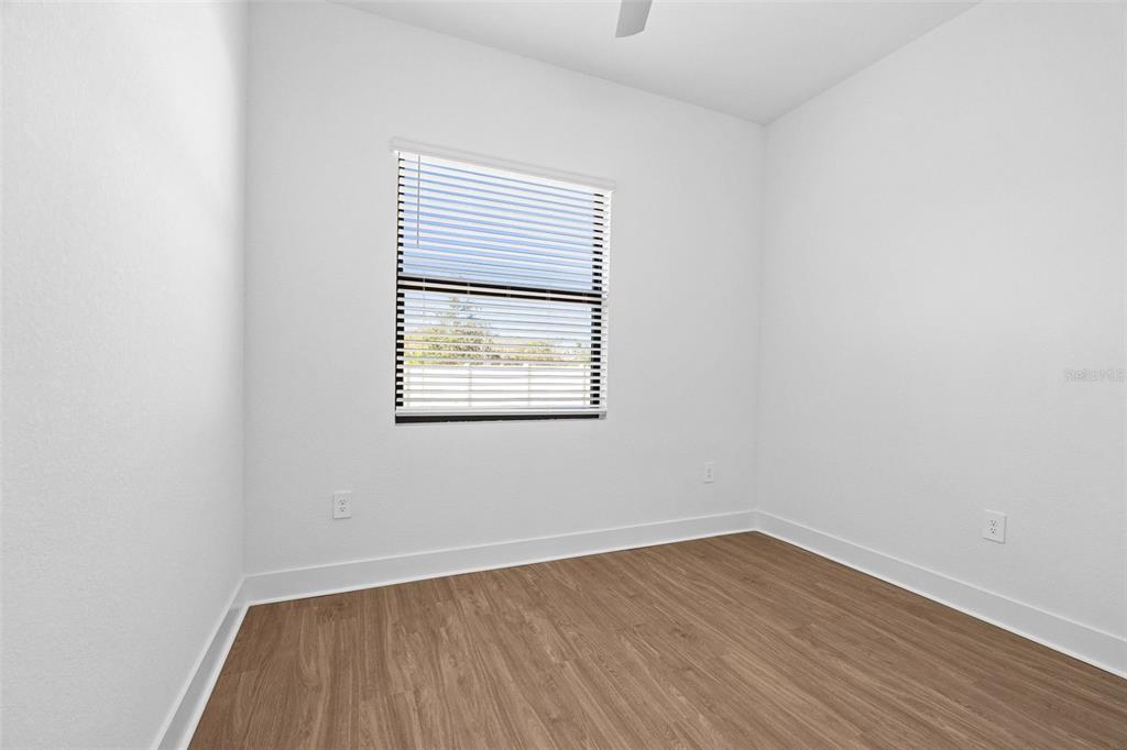 14413 Stellar Place Lakewood Ranch, FL 34202 - Photo 19 of 44 an empty room with wooden floor and windows