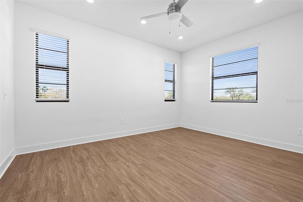 14413 Stellar Place Lakewood Ranch, FL 34202 - Photo 25 of 44 an empty room with wooden floor chandelier fan and windows