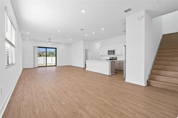 a view of a kitchen with wooden floor and electronic appliances