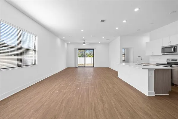 a view of kitchen with wooden floor and electronic appliances