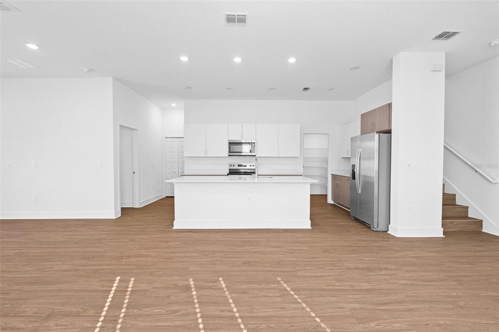 14413 Stellar Place Lakewood Ranch, FL 34202 - Photo 6 of 44 a large white kitchen with kitchen island a stove a refrigerator a sink and a cabinets