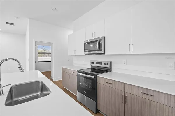 a kitchen with granite countertop white cabinets and stainless steel appliances