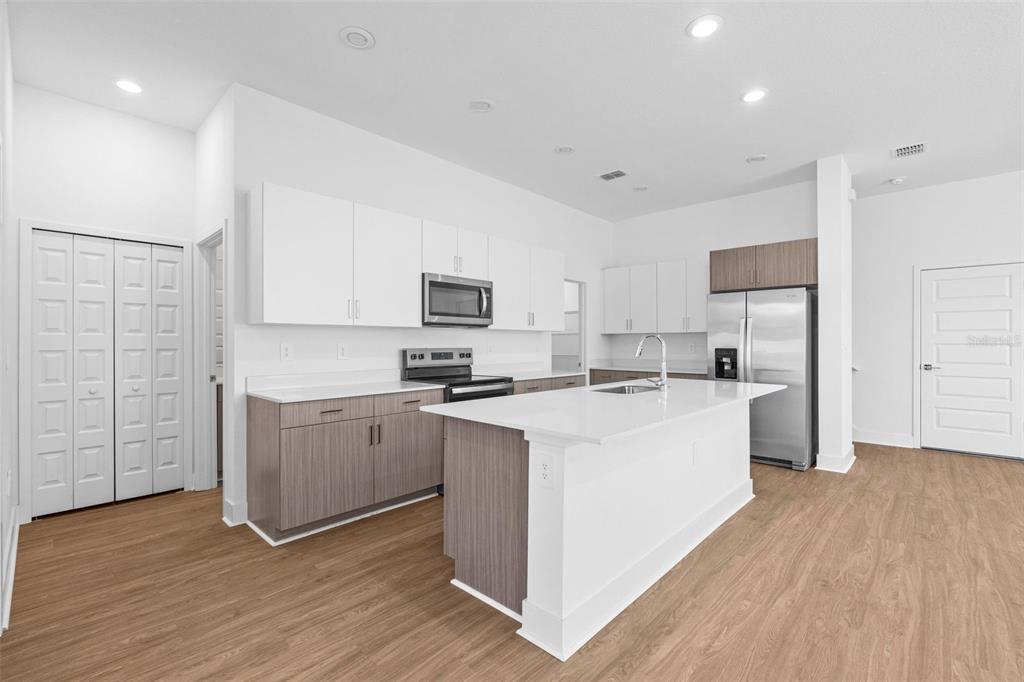 14413 Stellar Place Lakewood Ranch, FL 34202 - Photo 10 of 44 a kitchen with white cabinets and white appliances