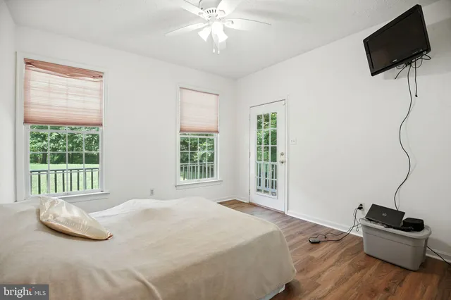 a bedroom with a bed window and a flat screen tv
