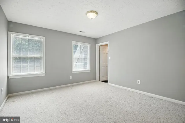 an empty room with windows and closet