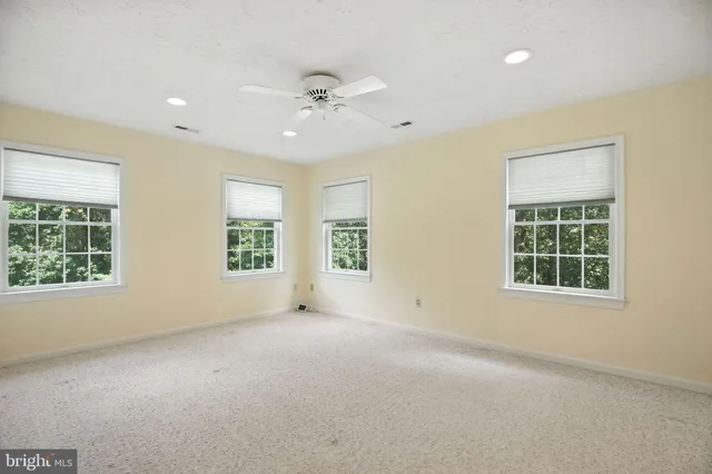 an empty room with windows and closet
